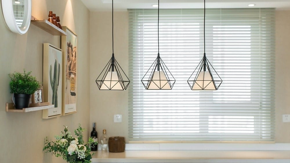 Kitchen with focus on three black geometric pendant lights.