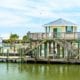 A house on the water with a pier surrounding it.