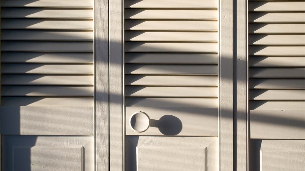 Close up of cream-colored bifold closet door that is closed