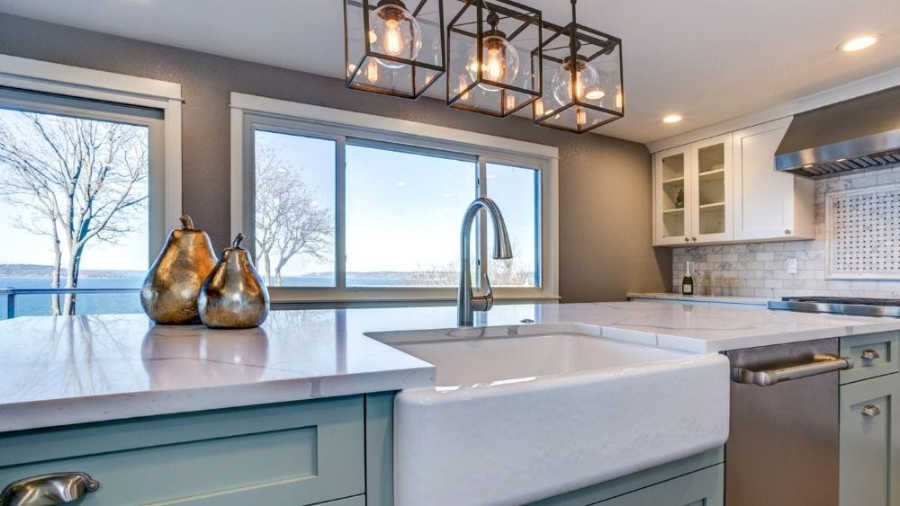 Modern kitchen with teal cabinets and a large farmhouse sink.