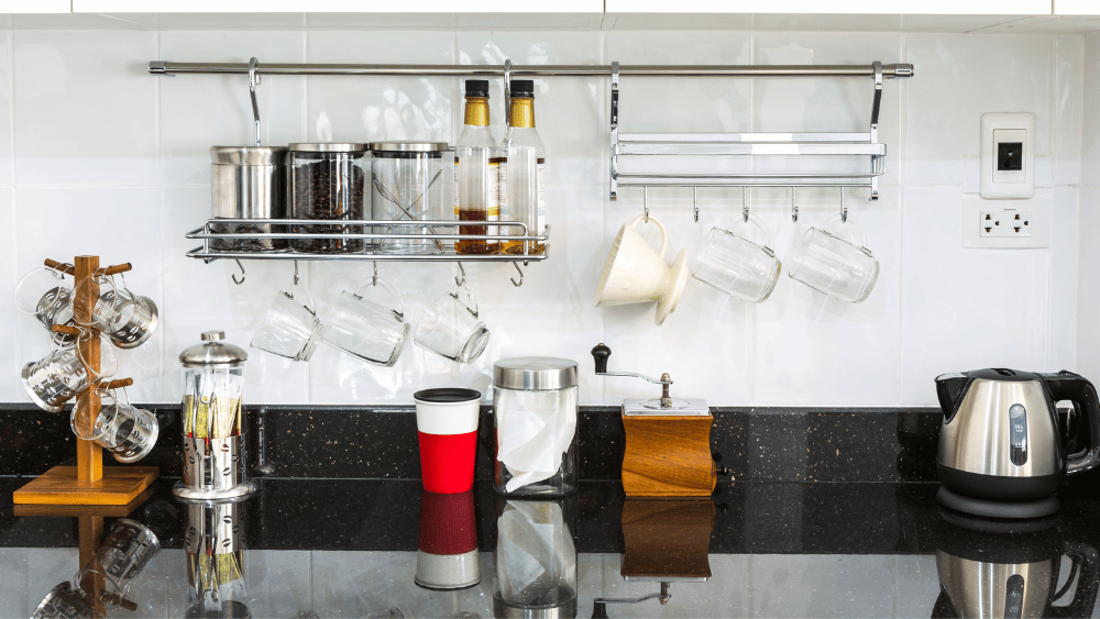 coffee bar home setup with hanging mugs, syrups, creamer, coffee pot