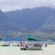 Kaneohe beach on Oahu, Hawaii with mountains in background and boats and people in foreground