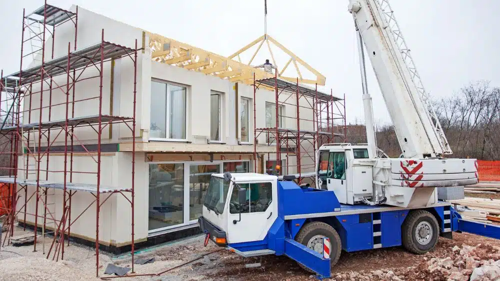 heavy equipment assembling a modular home